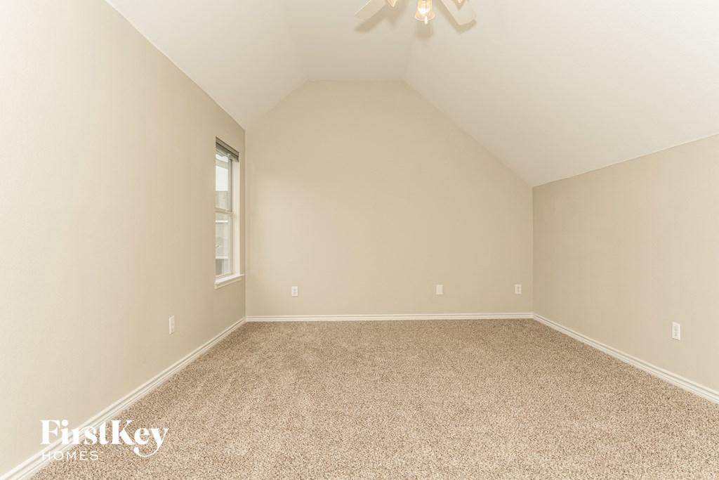 a empty room with carpet and a ceiling fan