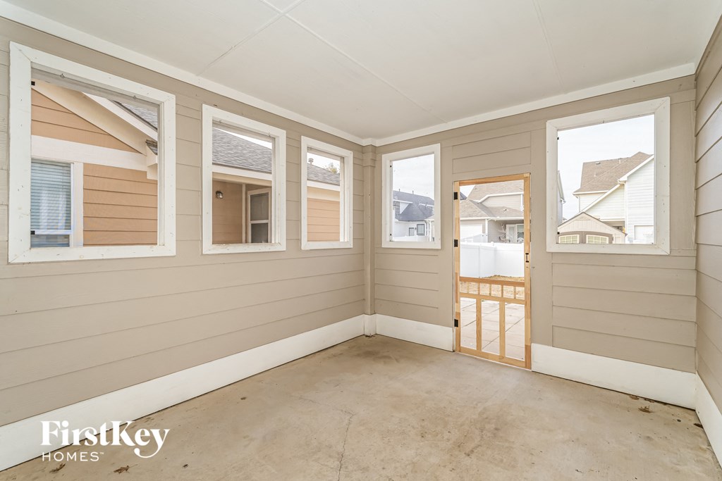 a living room with windows and a door to a balcony