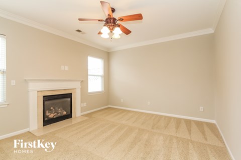 a living room with a ceiling fan and a fireplace