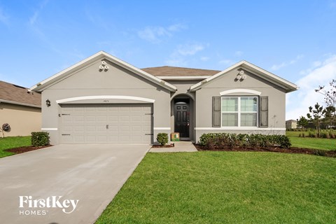 A house with a garage and a driveway in front of it.