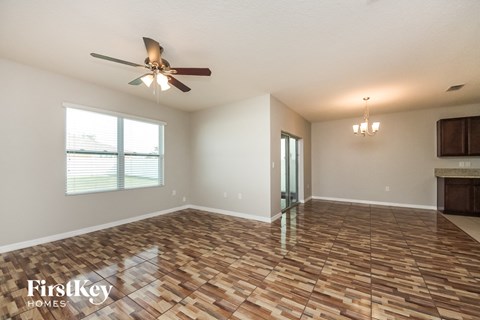 A room with wooden flooring and a ceiling fan.