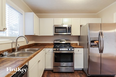 a kitchen with white cabinets and stainless steel appliances