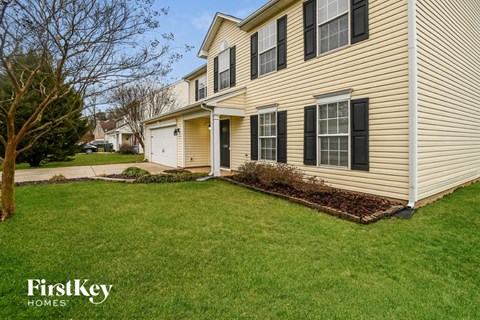 a side view of a house with a yard and grass