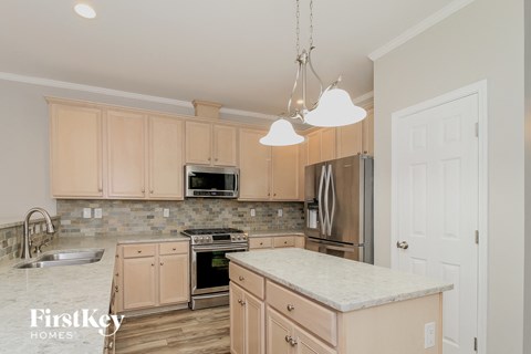 a kitchen with wooden cabinets and a marble counter top