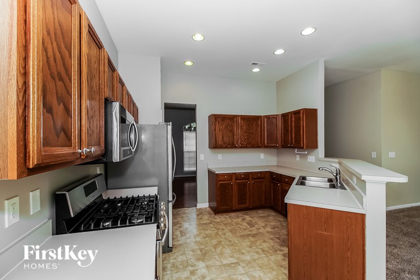 A kitchen with wooden cabinets and a stove top oven.