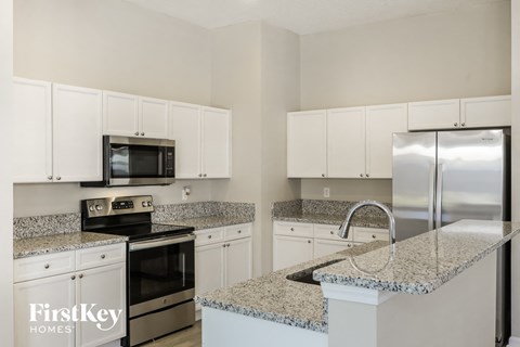 A kitchen with granite countertops and stainless steel appliances.