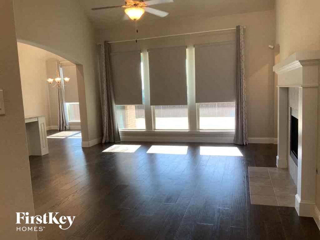 A spacious room with a fireplace and a large window.