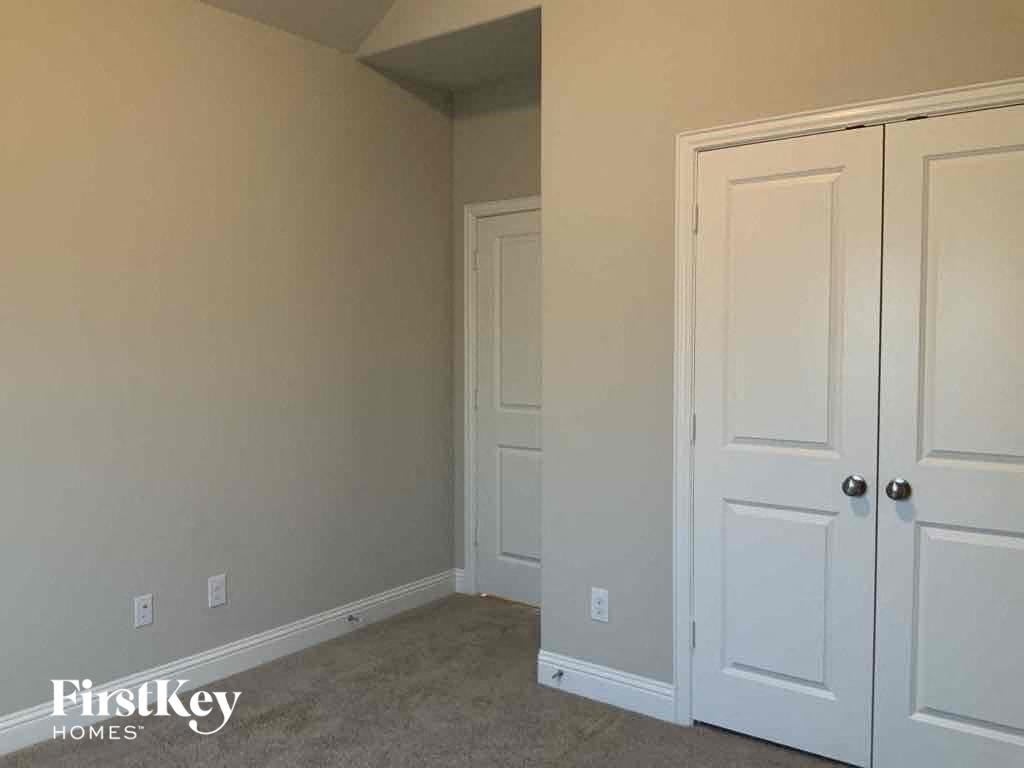 A room with a white door and a carpeted floor.