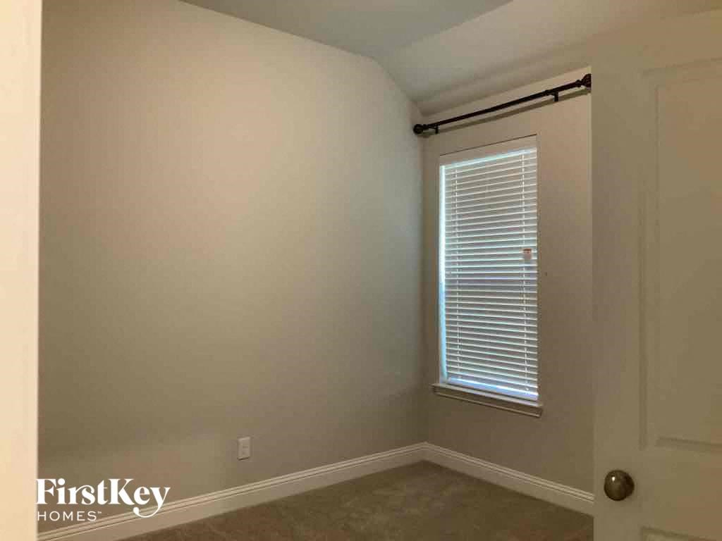 A room with a door and a window with blinds.