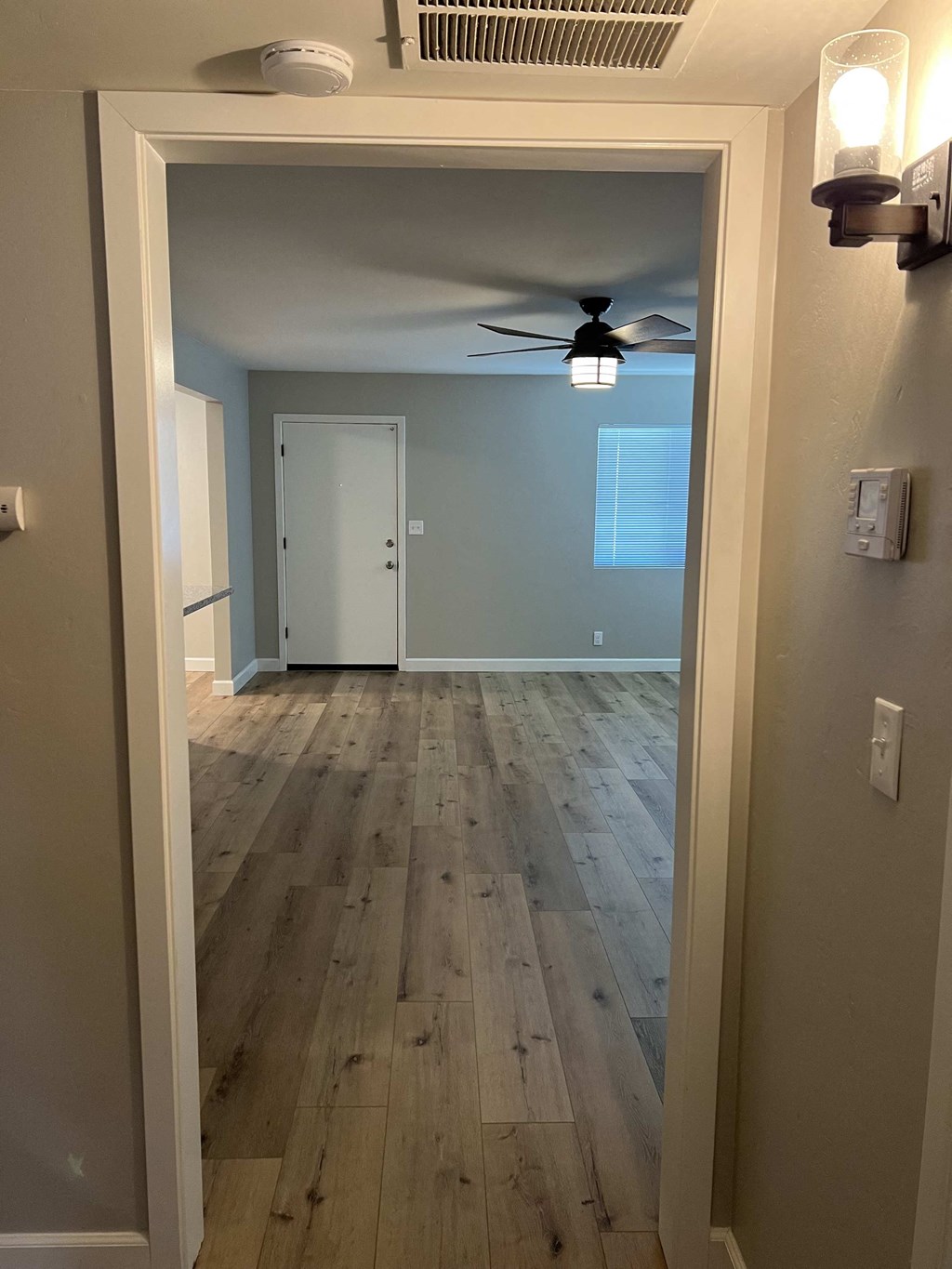 a living room with wood floors and a ceiling fan