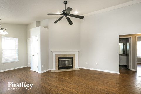 a living room with a fireplace and a ceiling fan
