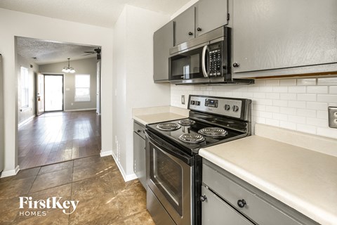 an empty kitchen with stainless steel appliances and white counter tops