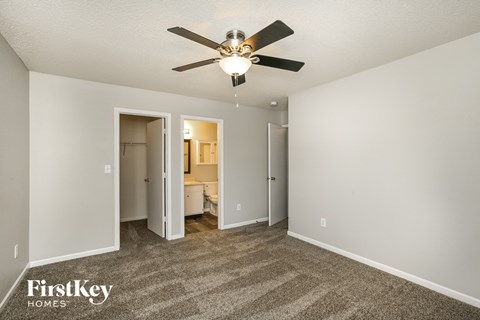 a living room with carpet and a ceiling fan