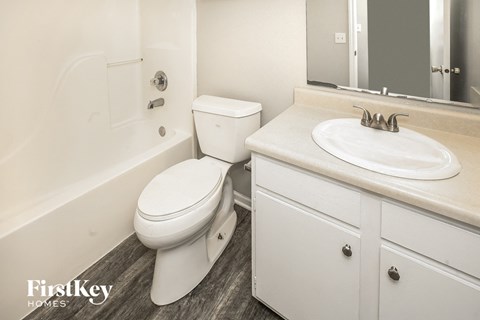 a bathroom with a toilet and a sink and a mirror