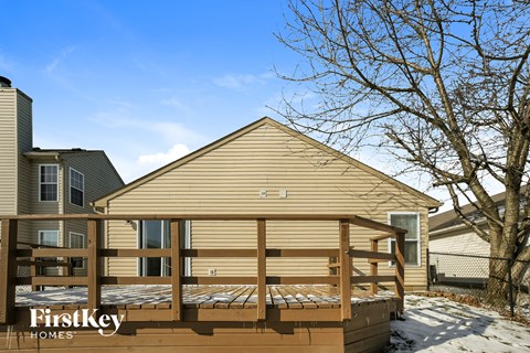 a deck with a privacy fence in front of a house
