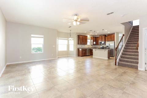 A spacious living room with a staircase leading to the upper floor.