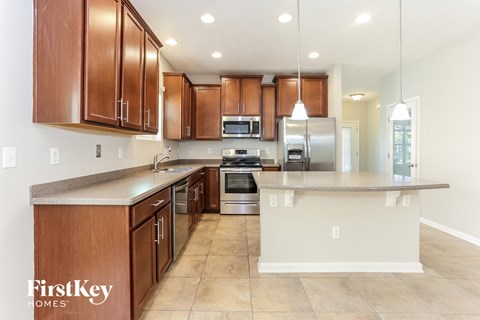 A kitchen with brown cabinets and a white island.