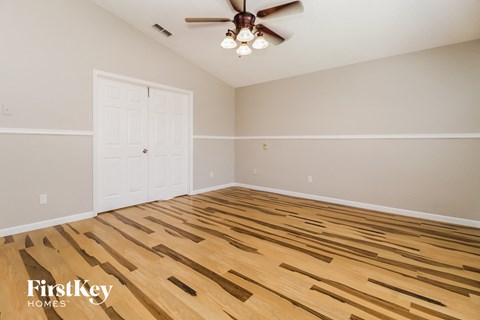 the living room has a hardwood floor and a ceiling fan