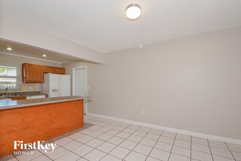 A kitchen with a wooden counter and white cabinets.