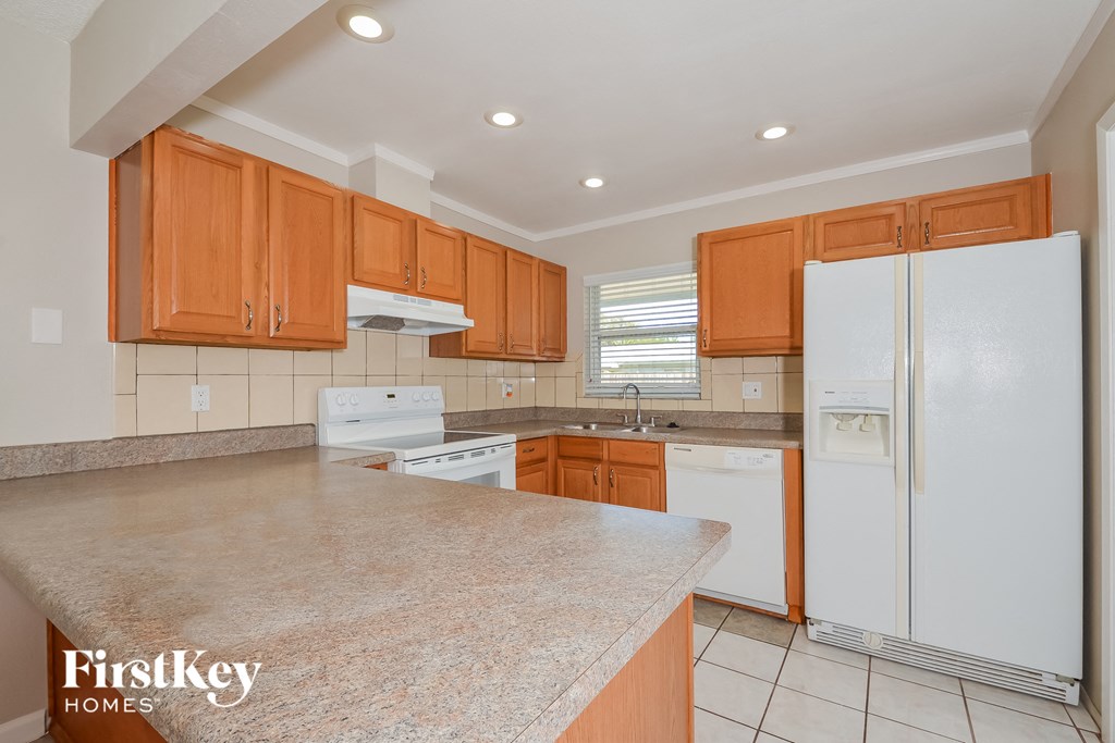 A kitchen with wooden cabinets and a white fridge.