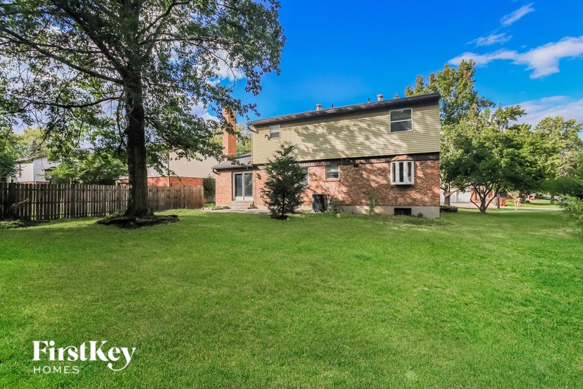 an old brick house with a yard and a tree