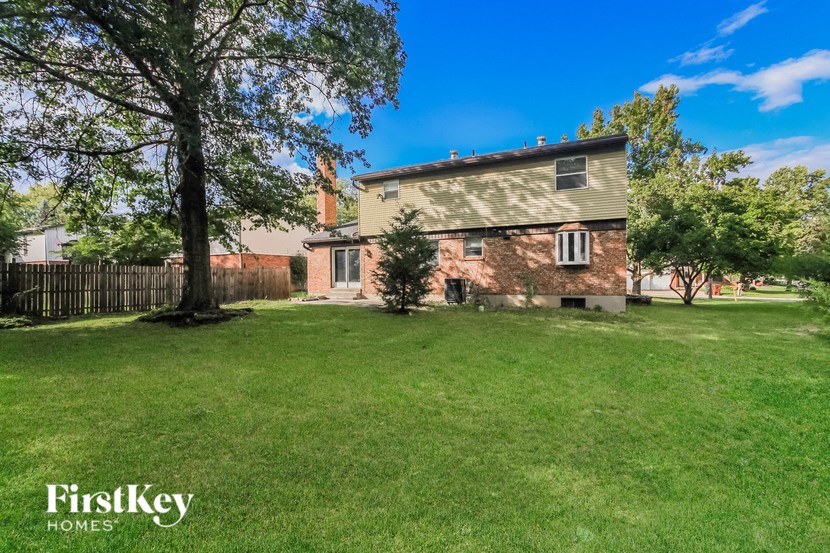 an old brick house with a yard and a tree