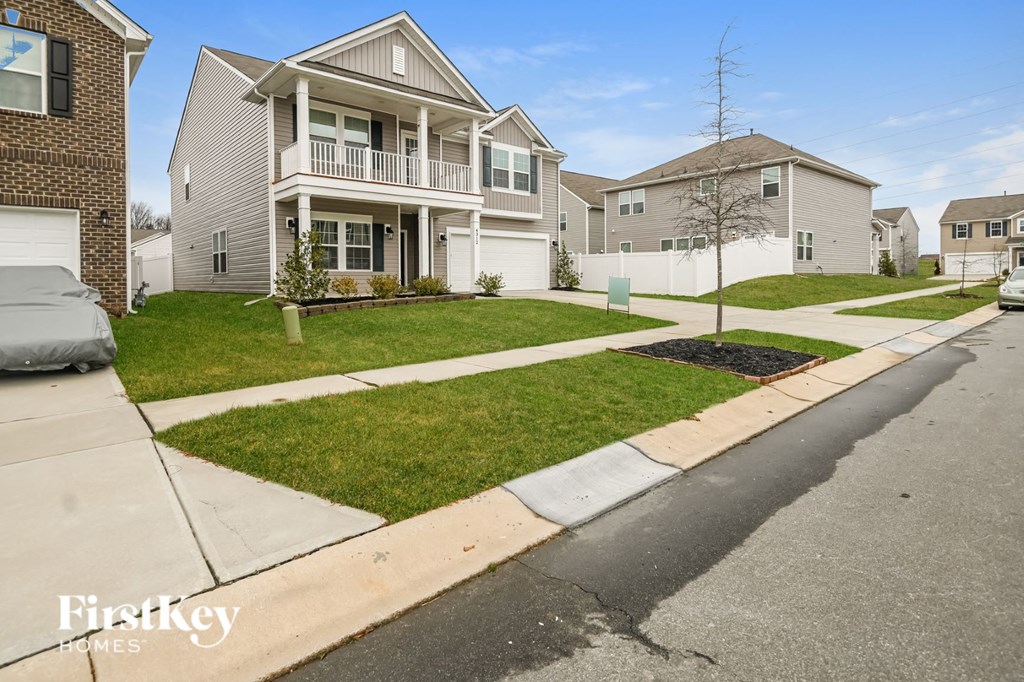 A residential street with houses and a clear sky.