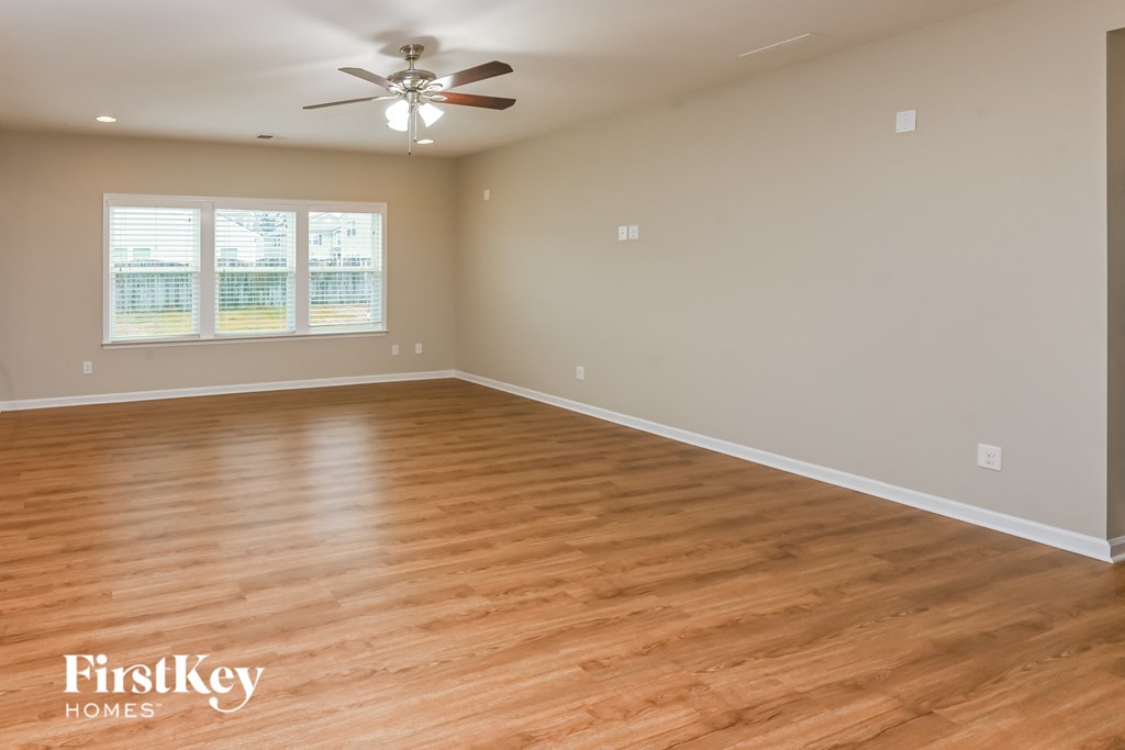 A room with wooden flooring and a ceiling fan.