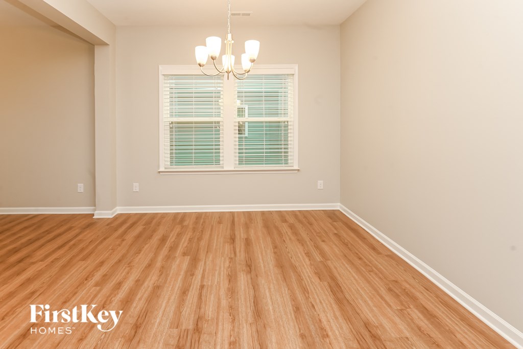 A room with wooden flooring and a chandelier.