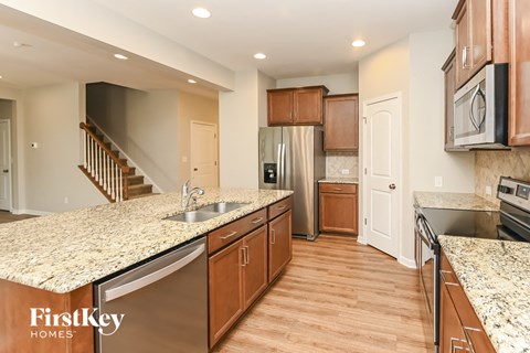 A kitchen with wooden cabinets and granite countertops.