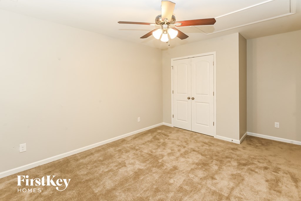 A room with a ceiling fan and a door.