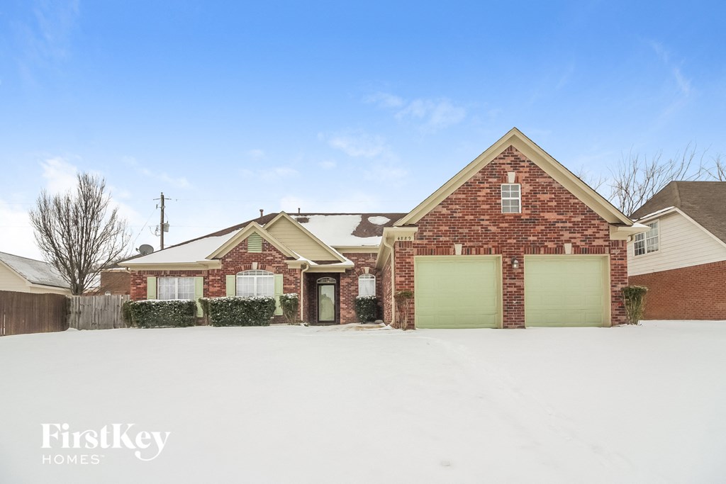 A brick house with a garage door is for sale.