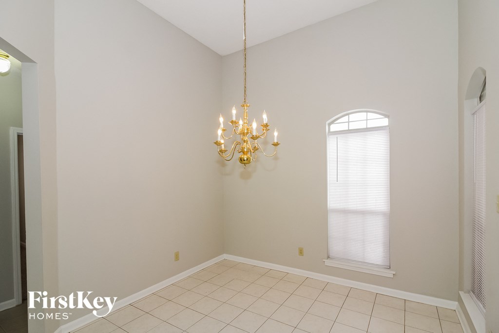 A room with a chandelier, a window, and a door.