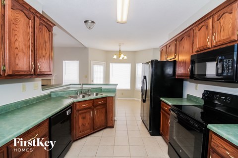 A kitchen with wooden cabinets and black appliances.