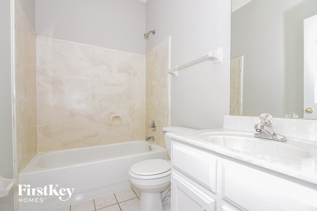 A white bathroom with a tub, toilet and sink.