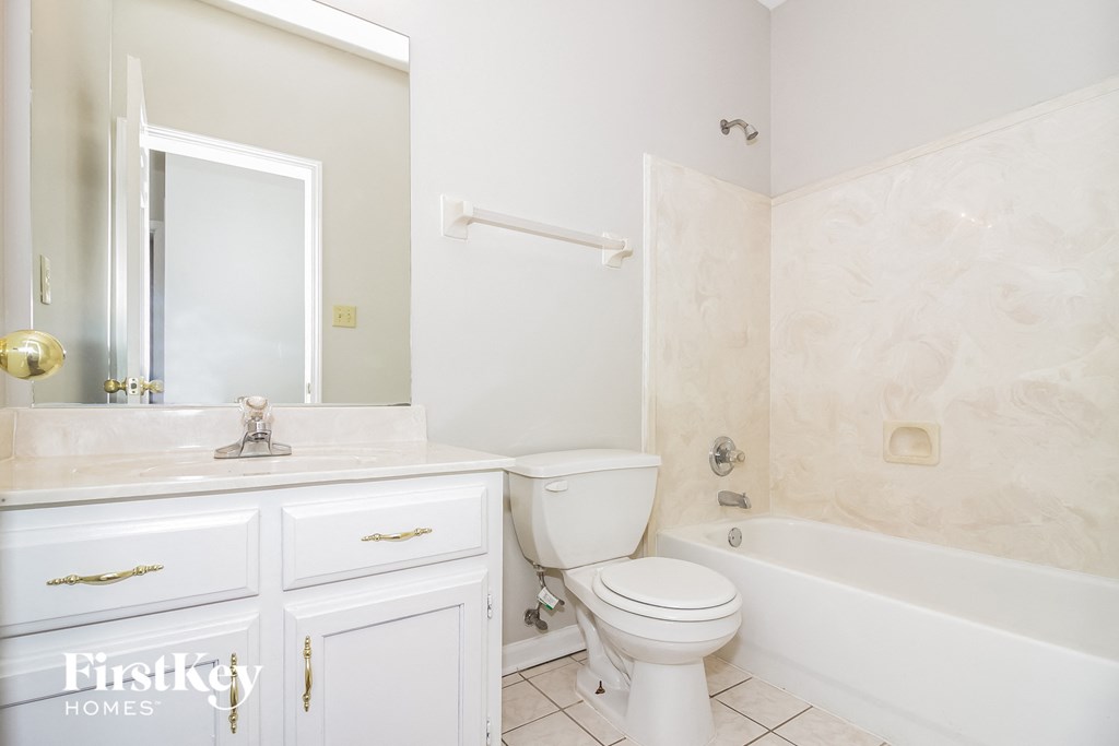 A white bathroom with a toilet, sink, and bathtub.