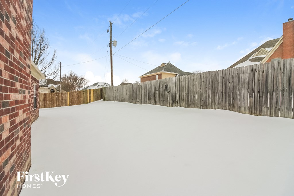 A backyard with a wooden fence and a clear sky.