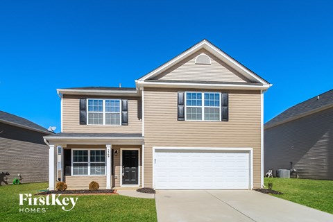 a tan house with a white garage door
