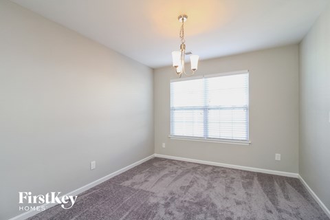 a spacious living room with carpet and a window