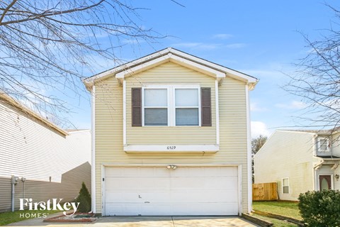 a yellow house with a white garage door