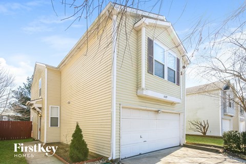 a yellow house with a white garage door
