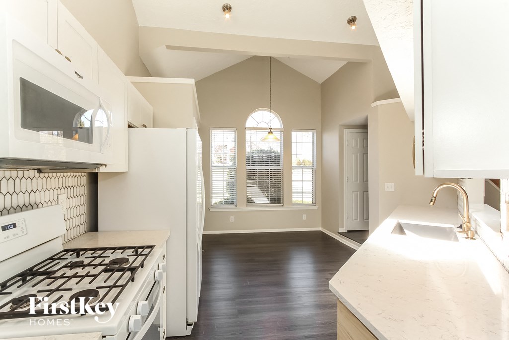 A kitchen with a stove top oven and a sink.