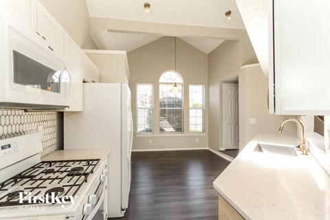 A kitchen with a stove top oven and a sink.