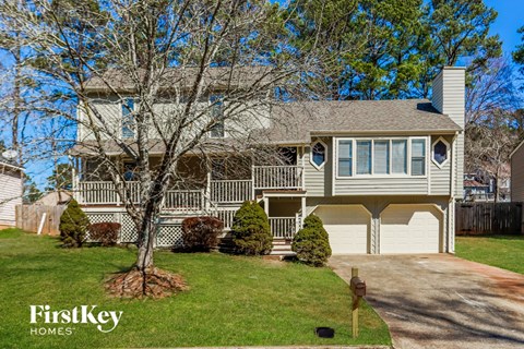 a large white house with a yard and a tree