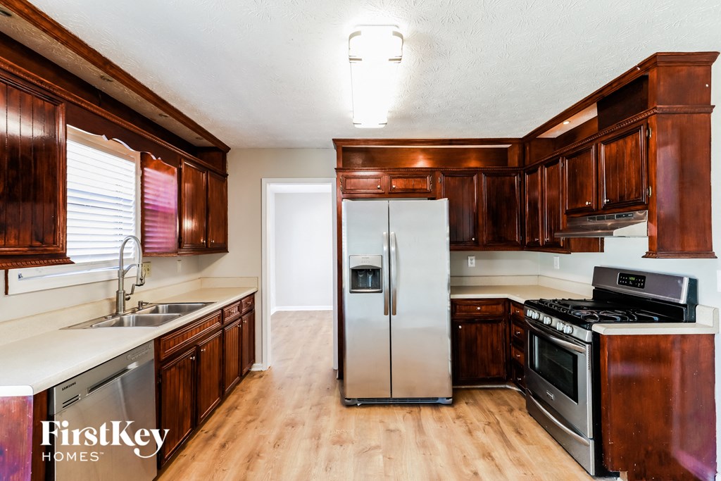 a kitchen with wooden cabinets and stainless steel refrigerator