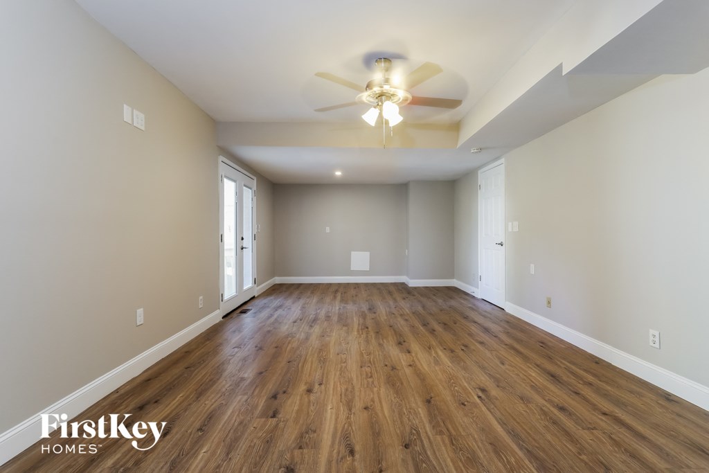 the living room of an empty house with a ceiling fan