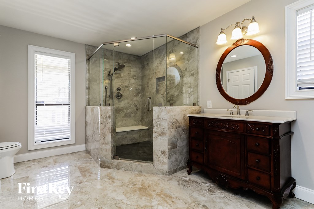 a bathroom with a shower and a sink and a vanity