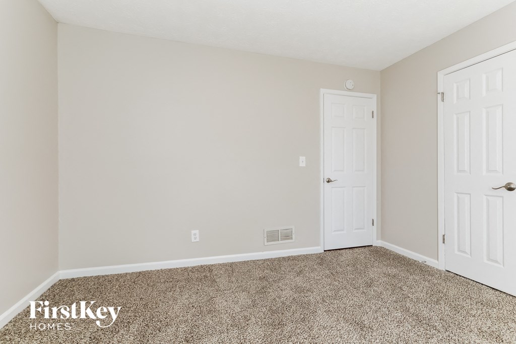 a bedroom with a carpeted floor and white doors