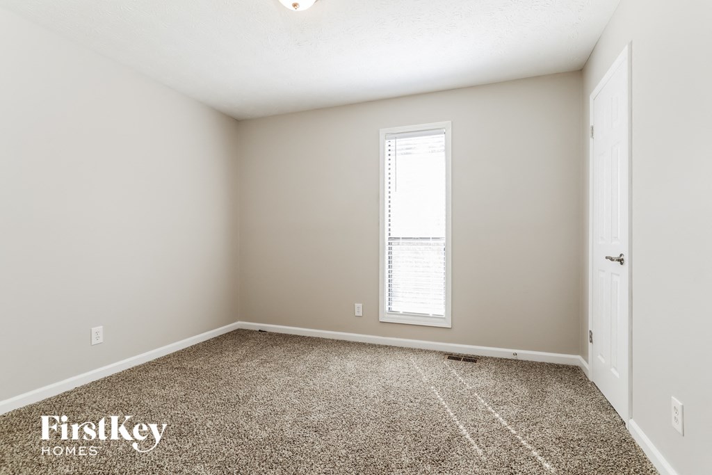 a spacious room with carpet and a window