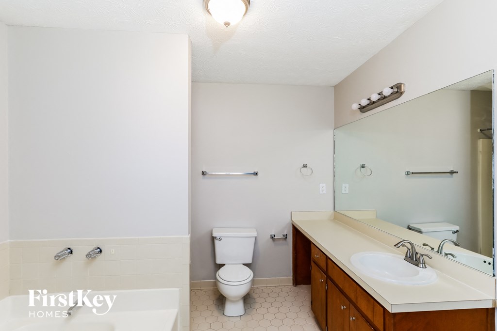 a bathroom with a toilet and a sink and a mirror